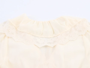 Close-up of beige French style ruffle collar with delicate lace trim on chiffon dress