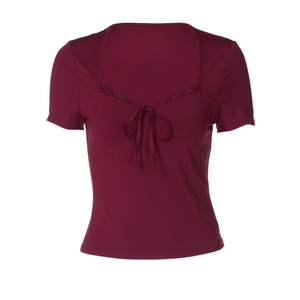 Détail de la bordure en dentelle et du nœud sur un t-shirt bordeaux cintré