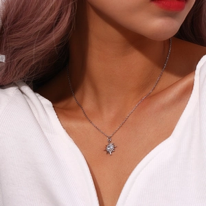 Detailed view of silver starburst pendant with sparkling zircon on a delicate chain