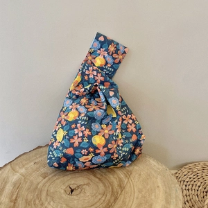 Detail view of cotton canvas floral wristlet bag with colorful botanical patterns