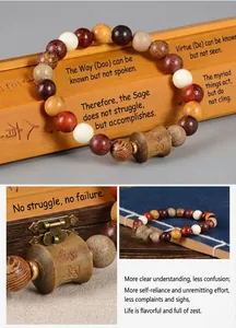 Bracelet de perles en bois de santal avec une breloque sculptée sur un tapis de bambou