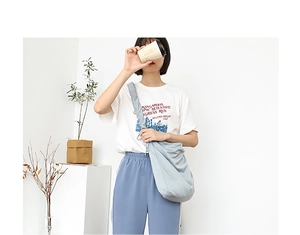 Detailed view of light blue nylon crossbody bag styled in a casual fashion setting
