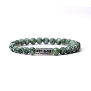 Vue détaillée des perles en pierre naturelle 6mm avec tube en métal gravé sur le bracelet