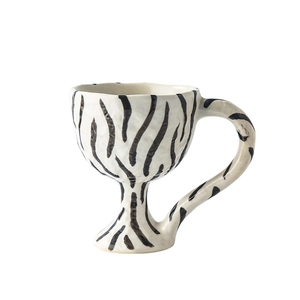 Handcrafted zebra print ceramic goblet with unique curved handle on white background