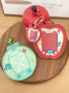 Detailed view of acrylic fruit-shaped card holders on a wooden tray with a white bead chain