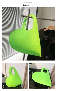 Detail of neon green heart-shaped felt bag showing asymmetric design and sleek stitching