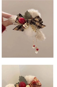Detail of Christmas plush hair claw clip with bell tassel and red berry accents
