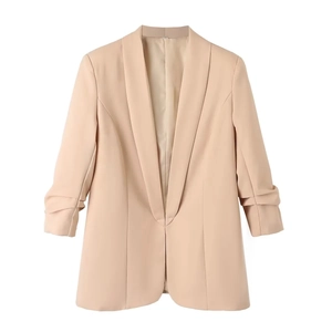 Detail van abrikooskleurige blazer met driekwart gerimpelde mouwen en revers