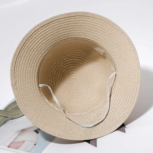 Detail view of the woven straw hat interior with sweatband and elastic chin strap