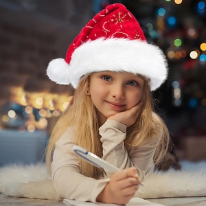 Close-up of a plush red Christmas hat with soft white trim worn by a child in festive lighting