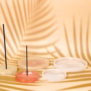 Detailed view of ribbed silicone incense burner trays in pink and white matte finish