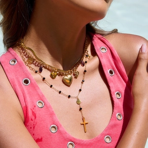 Close-up of layered 18K gold stainless steel necklace with heart and cross pendants