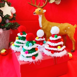 Detailed close-up of handmade knit Christmas tree hats with festive pom-poms and tassels