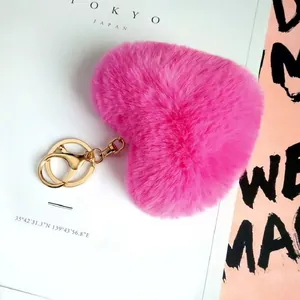 Dettaglio portachiavi a cuore in pelliccia sintetica rosa con gancio in metallo dorato
