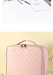 Detailed view of pink quilted cosmetic bag with gold double zippers and top handle