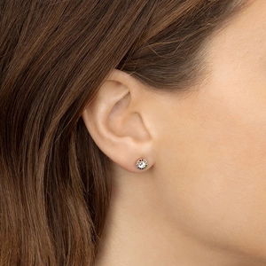 Macro shot of circular gold stud earrings with a rainbow of colorful cubic zirconia stones