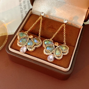 Detailed close-up of vintage butterfly tassel earrings with colorful crystals on velvet