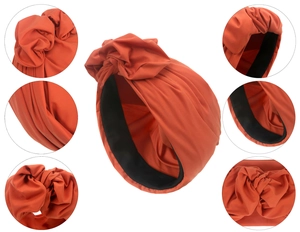 Detailansicht des brennend-orangen Turbans mit Faltenstruktur und schwarzem Innenfutter