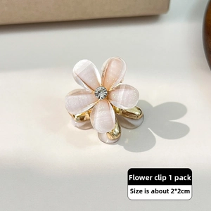 Macro shot of 2x2cm pearlescent flower mini claw clip with a sparkling rhinestone center