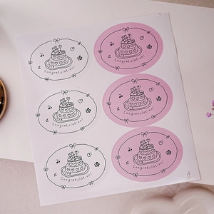 Detail of oval Happy Birthday stickers with hand-drawn cakes and hearts for gift wrapping