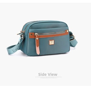 Detail view of the durable turquoise nylon crossbody bag with dual zipper pockets