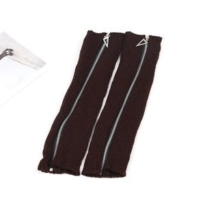 Detailed view of dark brown knitted leg warmers with silver metal zippers and triangle pulls
