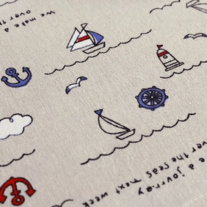 Macro detail of linen texture featuring nautical prints of sailboats and anchors