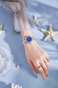 Close-up of elegant women watch with blue sunray dial and shimmering crystal bezel