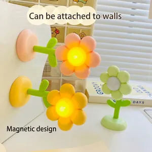 Creative flower-shaped magnetic night light in pink yellow and green colors on a desk
