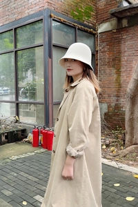 Chapeau cloche élégant en feutre de laine blanche avec un trench-coat beige pour l'hiver