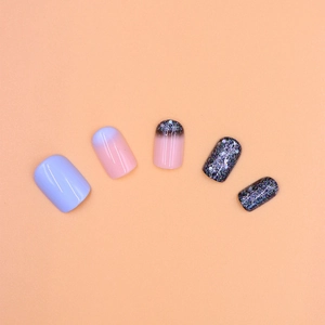 Detailed view of short press-on nails featuring fog blue glitter and gradient designs