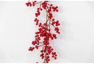 Detailed close-up of glossy artificial red Christmas berry stem against white wall
