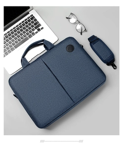 Detailed close-up of blue fabric laptop bag with detachable shoulder strap and accessories
