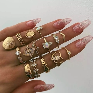 Detailed view of 13-piece gold metal ring set featuring bohemian coins and hand icons