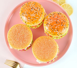 Detailed top view of four realistic PU artificial burgers on a pink plate with props