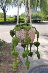 Handmade crochet plant car hanging with beige pot and green heart-shaped leaves