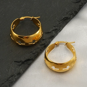 Detailed view of polished gold hoop earrings with cutout cross pattern on stone and silk