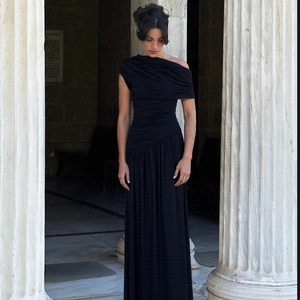 Detail of elegant black pleated evening dress with asymmetrical neckline and ruching