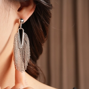 Close-up of silver beaded fringe earrings on a model showing elegant long tassel design