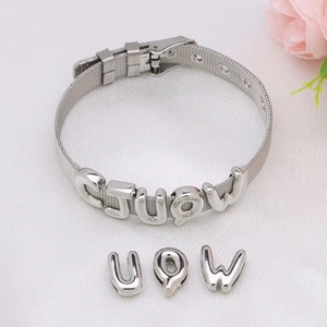 Silver mesh bracelet with bubble alphabet letter charms on elegant white silk background