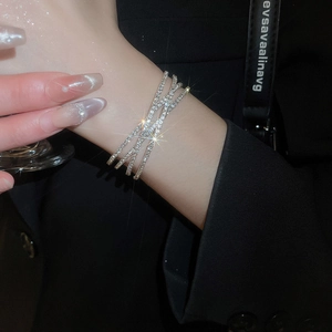 Close-up of a silver crisscross layered bracelet featuring brilliant full diamond crystals