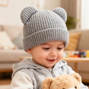 Detailed close-up of grey knitted baby winter hat with cute bear ears on a cozy background