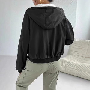 Detail of hooded jacket with warm white fleece lining and black nylon fabric texture