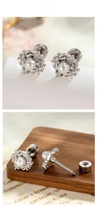 Detailed view of pearl earrings with screw back and intricate silver weave texture