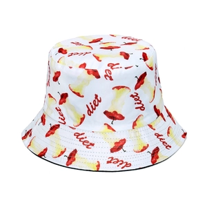 Detailed view of white bucket hat featuring red apple core pattern and diet text embroidery