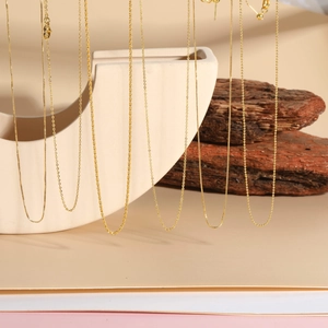 Close-up of various 18K gold plated chain styles including box and wave links