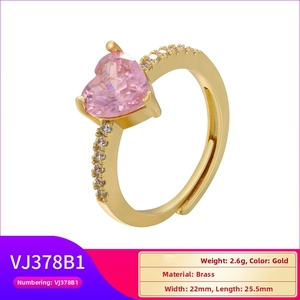 Macro detail of gold heart ring showing pink zircon inlay and brass material specs