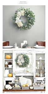 Detail of eucalyptus wreath with white roses and berries on a vintage mantel decor