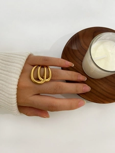 Detail of 18K gold multi-layer wrap ring showing a unique stacked design on a finger