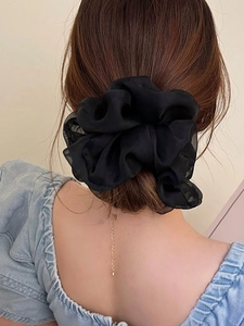 Close-up of a black mesh organza scrunchie tied on a ponytail with fluffy pleats
